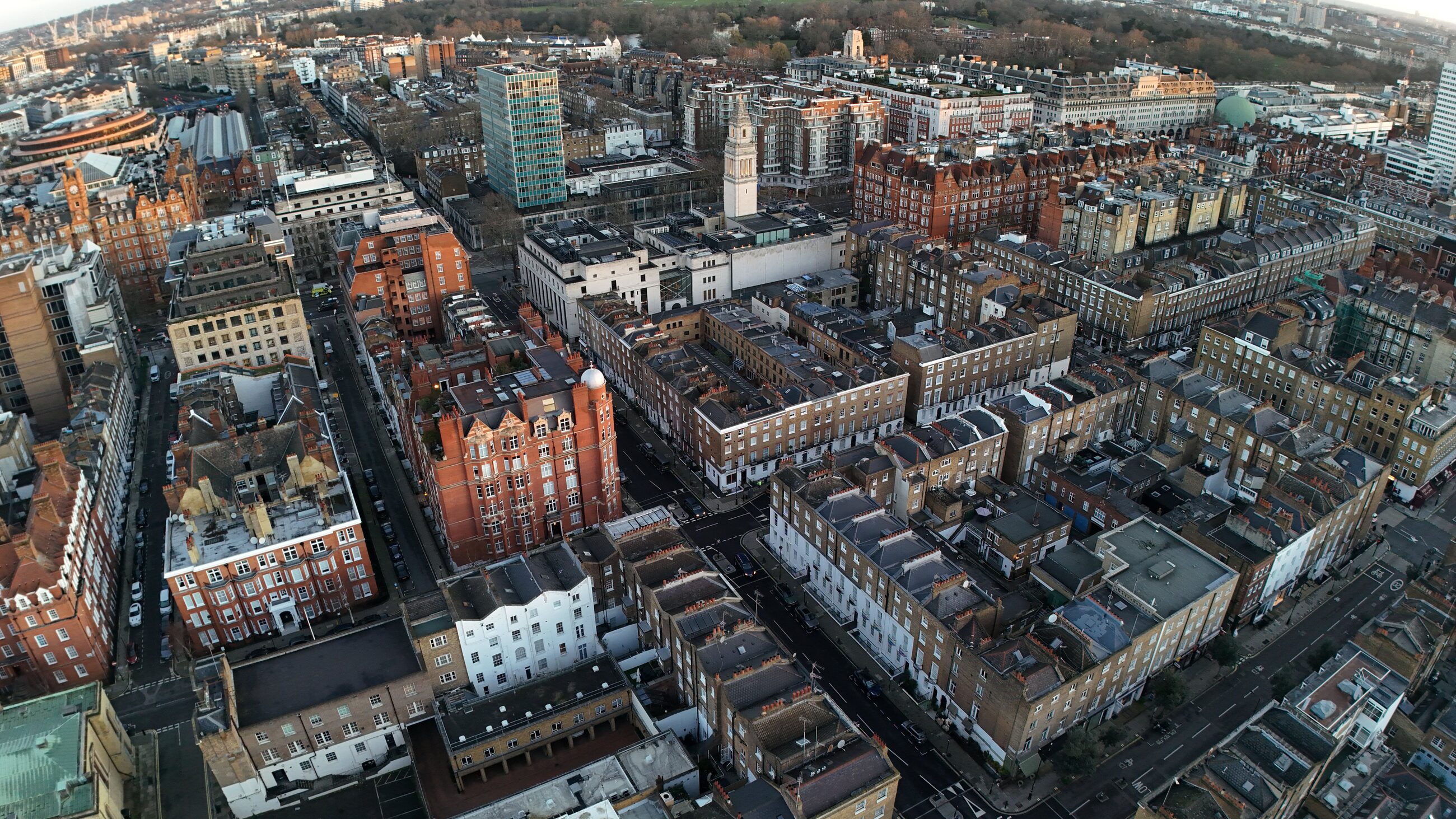 Aerial of Marylebone rooftops at first light, red-brick mansion blocks and terraces stretching toward Regent's Park