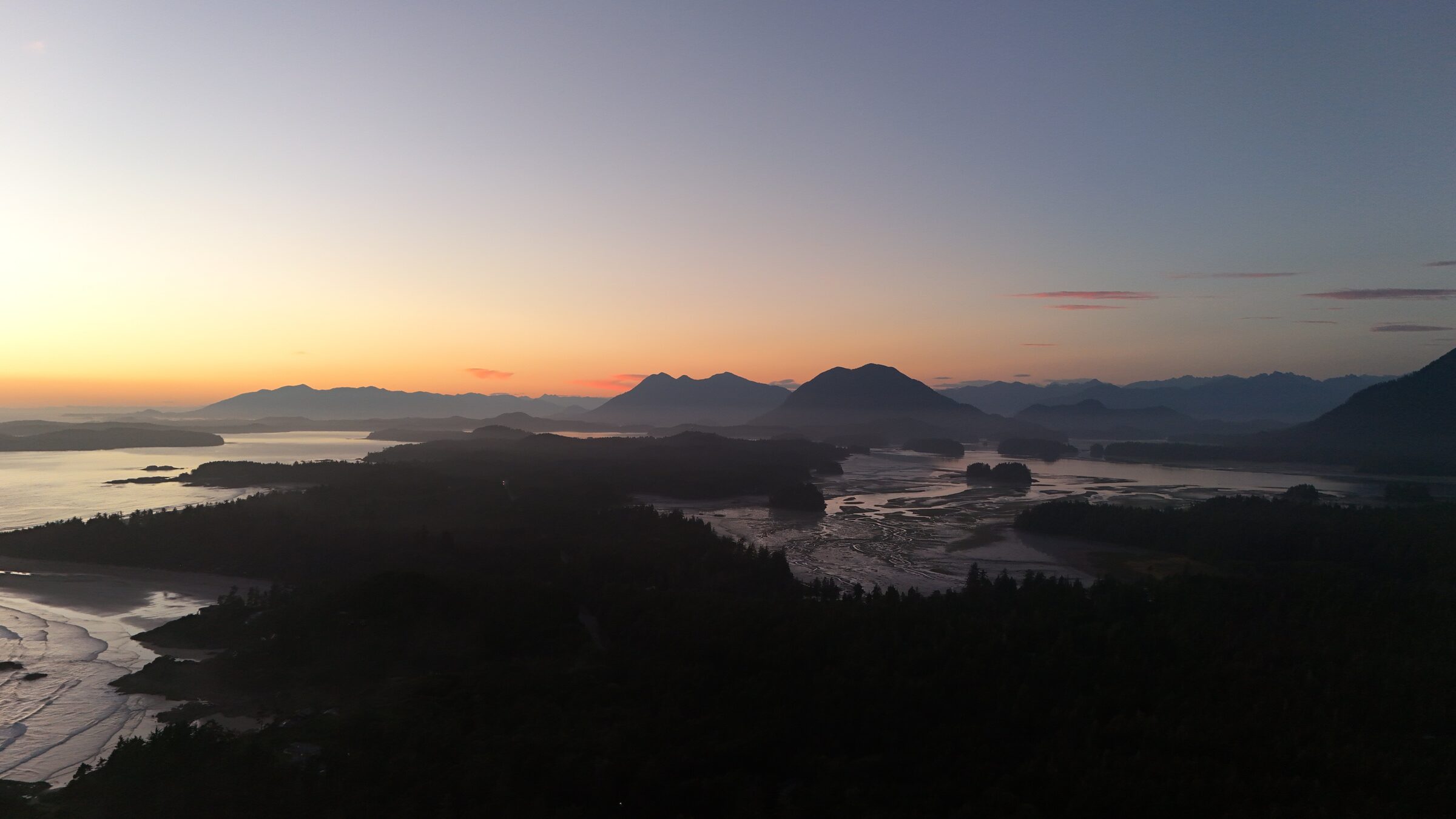 Dusk aerial of inlets and mountain silhouettes on the Pacific coast